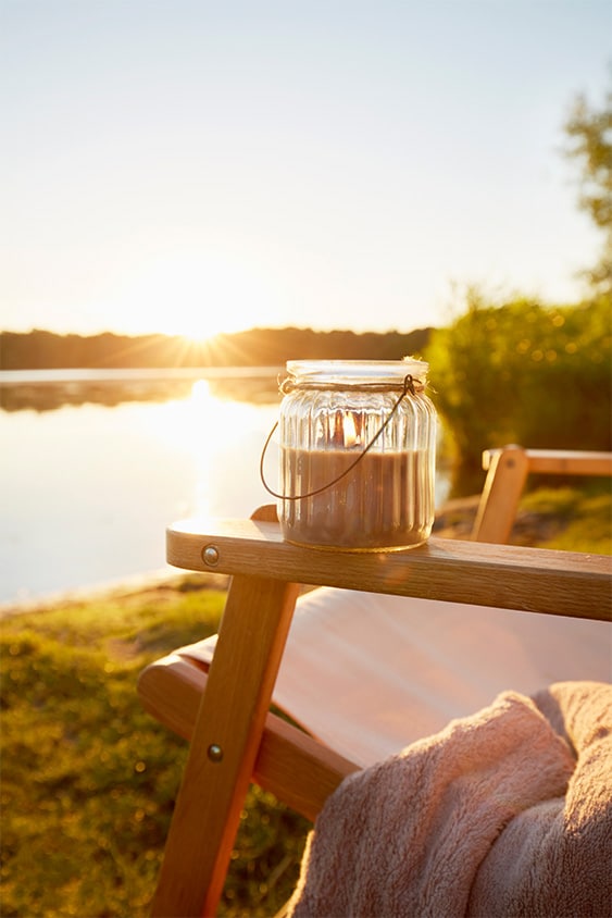 candle on the armrest of a chair overlooking a lake at oakfields nature park