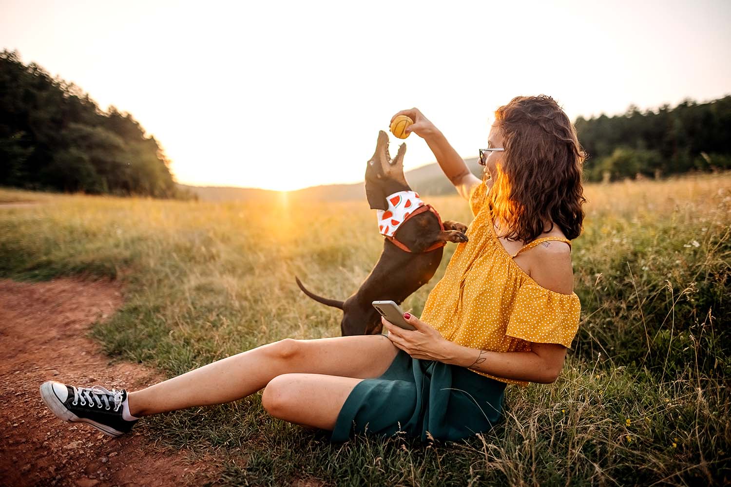 woman playing with a dog in a field at oakfield