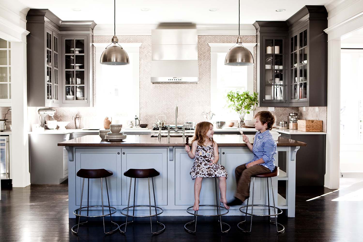 kids sitting on stools at an island in a beautiful kitchen