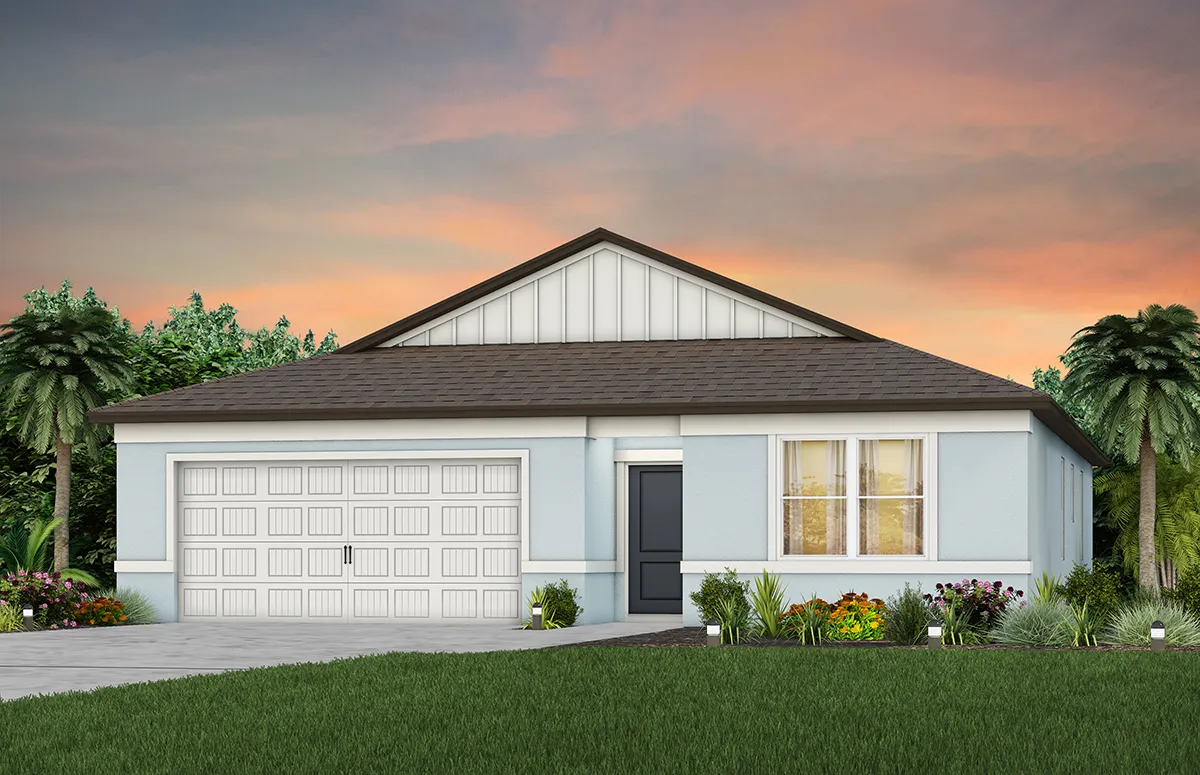A single-story house with a gray roof, light blue exterior, double garage, front door, and large windows. The yard has green grass, colorful flower beds, and palm trees, with a sunset sky in the background.
