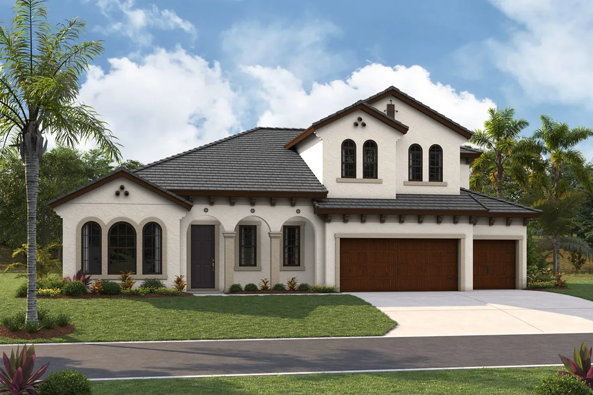 A two-story Mediterranean-style house with white stucco walls, dark tiled roof, arched windows, and a three-car wooden garage, surrounded by green lawn, palm trees, and shrubs under a partly cloudy sky.