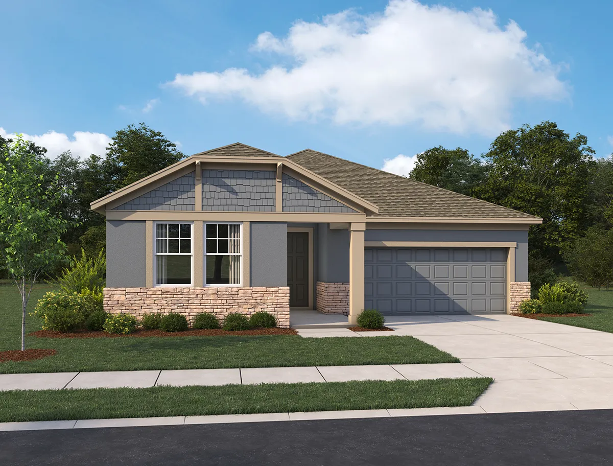 Single-story suburban house with gray siding, stone accents, and a two-car garage. The front yard has small shrubs, a young tree, and a manicured lawn, with a paved driveway and walkway leading to the entrance.