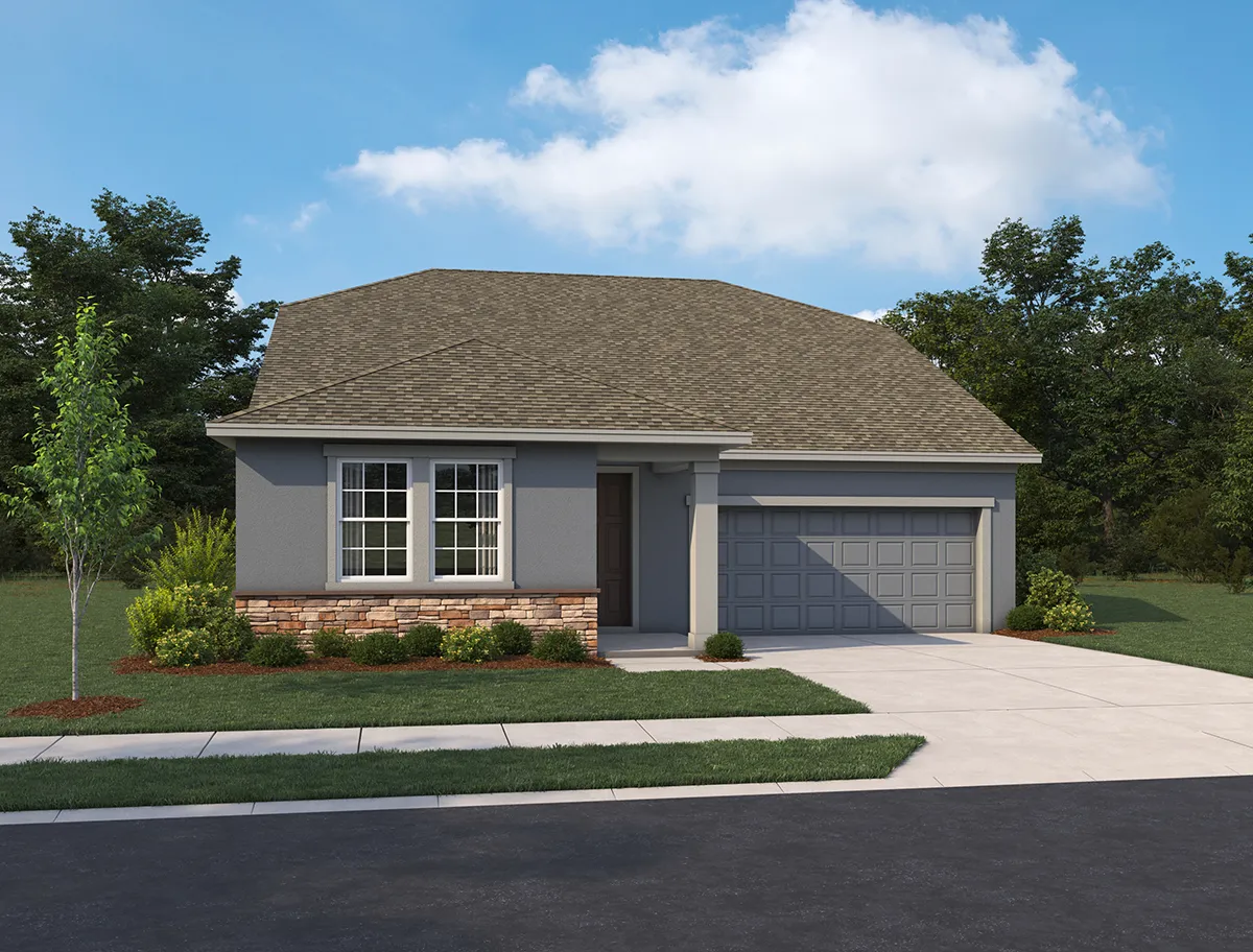 Single-story house with a gray exterior, two-car garage, small front yard with shrubs and a young tree, set against a backdrop of trees and a partly cloudy sky.